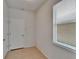 Hallway with tiled floor, window, and a white paneled door leading to additional rooms at 12150 Ledbury Commons Dr, Gibsonton, FL 33534