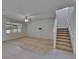 Spacious living room with a ceiling fan, light beige carpet, and stairs leading to the second floor at 12150 Ledbury Commons Dr, Gibsonton, FL 33534