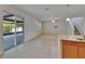 Bright living room with tiled floors, ceiling fan, and sliding glass doors to the screened-in patio at 12150 Ledbury Commons Dr, Gibsonton, FL 33534