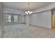 Bright living room featuring neutral tones, large windows, carpet floors, and stylish lighting fixtures at 12150 Ledbury Commons Dr, Gibsonton, FL 33534