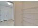 Walk-in pantry with metal shelving and a view of a hallway with a white paneled door at 12150 Ledbury Commons Dr, Gibsonton, FL 33534