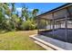 Screened-in patio with a view of the backyard, surrounded by lush trees at 12150 Ledbury Commons Dr, Gibsonton, FL 33534