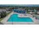 Large community pool with sun loungers and shaded seating areas surrounded by lush landscaping at 12150 Ledbury Commons Dr, Gibsonton, FL 33534