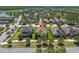 An aerial view showcases the house in a serene community, surrounded by lush greenery and a nearby lake at 12462 Rangeland Blvd, Odessa, FL 33556