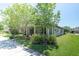 A charming single-story home featuring mature trees, lush landscaping, and a welcoming walkway at 12462 Rangeland Blvd, Odessa, FL 33556