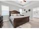 Serene main bedroom with a dark wood bed frame and neutral decor, with windows providing ample natural light at 12462 Rangeland Blvd, Odessa, FL 33556