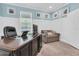 Well-lit home office with white trim and a dark desk, complemented by a comfortable gray sofa and a window view at 12462 Rangeland Blvd, Odessa, FL 33556