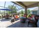 Screened in lanai featuring brick pavers, fire pit, and wicker furniture at 12462 Rangeland Blvd, Odessa, FL 33556