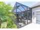 A screened-in patio offers outdoor entertaining space with a dining area and a tranquil view at 12462 Rangeland Blvd, Odessa, FL 33556