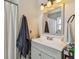 Bathroom featuring a gray vanity, a shower and tub combination, and a well lit vanity mirror at 13749 80Th Ave, Seminole, FL 33776