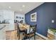 Cozy dining area featuring a wooden table set for four, adjacent to a well-equipped kitchen and blue accent wall at 13749 80Th Ave, Seminole, FL 33776