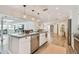 Open-concept kitchen featuring a large island, granite countertops, stainless steel appliances, and wood flooring at 13749 80Th Ave, Seminole, FL 33776