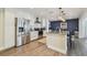 Modern kitchen boasts stainless steel appliances, granite countertops, and an island with seating for dining at 13749 80Th Ave, Seminole, FL 33776