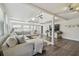 Spacious living room with beamed ceilings, ceiling fan, plank flooring, and large gray sectional couch at 13749 80Th Ave, Seminole, FL 33776