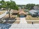 An aerial view of a well-maintained home in a quiet neighborhood with a mature tree in the front yard at 1615 Loghill Pl, Brandon, FL 33510