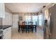 Bright dining room with large window, stylish light fixture, and stainless steel refrigerator at 1615 Loghill Pl, Brandon, FL 33510