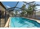 A refreshing screened-in swimming pool surrounded by tropical landscaping at 1615 Loghill Pl, Brandon, FL 33510