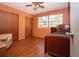 Orange bedroom with ceiling fan, laminate floor, bed, and view to the outside at 1616 Lightfoot Rd, Wimauma, FL 33598