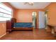 Bedroom with laminate floors, orange walls, view to the bathroom, bed, and view to the outside at 1616 Lightfoot Rd, Wimauma, FL 33598