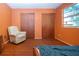 Bedroom with laminate floors, large closet, orange walls, ceiling fan, and bed at 1616 Lightfoot Rd, Wimauma, FL 33598