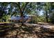 Charming stilt home featuring a quaint porch and surrounded by mature trees, offering a serene retreat at 1616 Lightfoot Rd, Wimauma, FL 33598