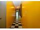 Hallway with checkerboard flooring and bright yellow walls offer a unique design at 1616 Lightfoot Rd, Wimauma, FL 33598