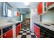 This modern kitchen offers checkerboard flooring, contrasting cabinets, and stainless steel appliances at 1616 Lightfoot Rd, Wimauma, FL 33598