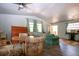 Open-plan living room with hardwood floors, desk, and comfortable turquoise-colored seating at 1616 Lightfoot Rd, Wimauma, FL 33598