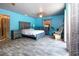 Bright main bedroom featuring ceiling fan, gray furniture set, wood floors, and access to a deck at 1616 Lightfoot Rd, Wimauma, FL 33598