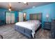 Charming main bedroom with blue walls, ceiling fan, laminate floors, and gray bedroom furniture set at 1616 Lightfoot Rd, Wimauma, FL 33598