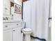 Well-lit bathroom featuring a white vanity, toilet and a shower with a blue-trimmed curtain at 1700 25Th N St, St Petersburg, FL 33713