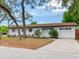 Attractive single-story house featuring a pristine white exterior, beautiful landscaping and a one-car garage at 1700 25Th N St, St Petersburg, FL 33713
