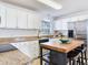 Bright kitchen featuring granite counters, white cabinetry, and a center island with stools at 1700 25Th N St, St Petersburg, FL 33713