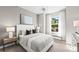 This serene bedroom has a luxurious bed, a bright window view, and contemporary lamps on the nightstands at 17085 Moonflower Dr, Venice, FL 34293