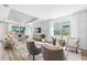 Elegant living room featuring tray ceilings, stylish wall paneling, and abundant natural light at 17085 Moonflower Dr, Venice, FL 34293