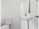 Clean bathroom with white pedestal sink, toilet, and a minimalist design, perfect for a modern touch at 1913 W Pine St, Tampa, FL 33607