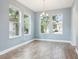 Bright dining room featuring wood-look tile floors, a modern light fixture, and three large windows at 1913 W Pine St, Tampa, FL 33607
