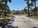 Community center showcasing lush palm trees, an American flag, and inviting landscaping, fostering a sense of community at 2055 Sunset Point Rd # 3804, Clearwater, FL 33765