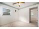 This bedroom is carpeted, features a ceiling fan, and is illuminated by natural light through a window at 20653 Old Trilby Rd, Dade City, FL 33523