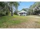 Charming single-story home with a metal roof and inviting front porch, surrounded by lush greenery at 20653 Old Trilby Rd, Dade City, FL 33523