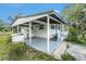 The side exterior showcases a covered carport and a covered porch with stairs, highlighting outdoor access at 20653 Old Trilby Rd, Dade City, FL 33523