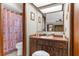 Bathroom with a vintage-inspired vanity, a large mirror, and a tub/shower with a patterned curtain at 2072 Maguire Ave, Spring Hill, FL 34608