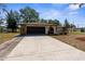 Home exterior with a paved driveway and stone accents, set against a partly cloudy sky at 2072 Maguire Ave, Spring Hill, FL 34608