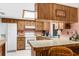 Well-lit kitchen features light countertops, wooden cabinetry, and a built-in breakfast bar at 2072 Maguire Ave, Spring Hill, FL 34608