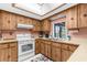 Bright kitchen with light-colored countertops, wood cabinets, skylight and clean appliances at 2072 Maguire Ave, Spring Hill, FL 34608