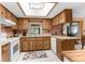 Well-lit kitchen features ample cabinet space, a bright skylight, and white appliances at 2072 Maguire Ave, Spring Hill, FL 34608