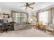 Well-lit living room with neutral-toned furniture, two windows, and computer desk at 2072 Maguire Ave, Spring Hill, FL 34608
