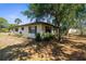 Home exterior surrounded by large trees and well-maintained lawn at 2072 Maguire Ave, Spring Hill, FL 34608