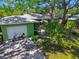 Lush backyard with a detached garage and lovely green exterior featuring trees and a scooter at 220 22Nd Se Ave, St Petersburg, FL 33705