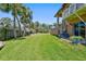 Large backyard with well-manicured lawn, tropical trees and view of the house at 2605 59Th S St, Gulfport, FL 33707